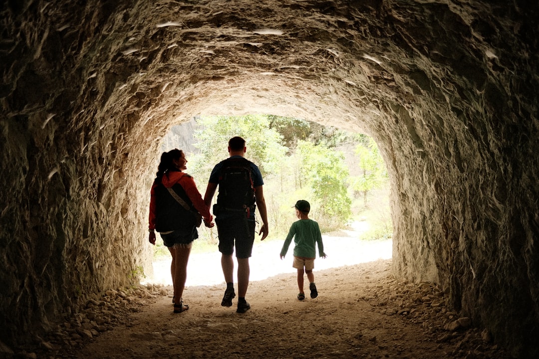 Family walking through a sunlit stone tunnel on a day out